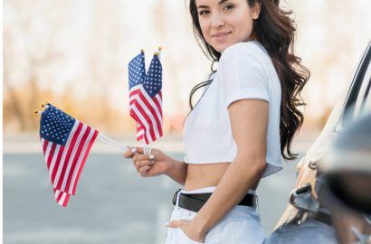 Woman holding US flags celebrating permanent residency and immigration